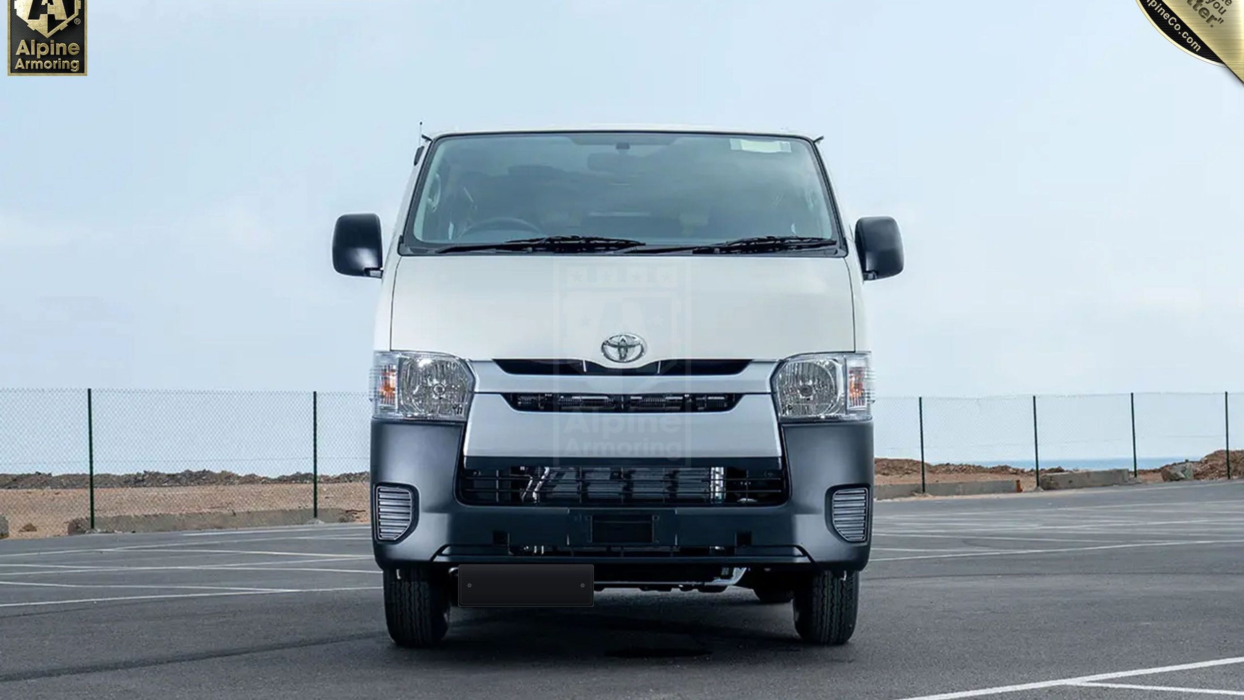 Armoured Toyota HiAce tactical passenger commuter van front three-quarter studio photography on white infinity cyclorama